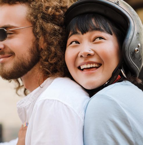 happy-young-multiethnic-couple-on-scooter-2021-12-09-19-48-40-utc